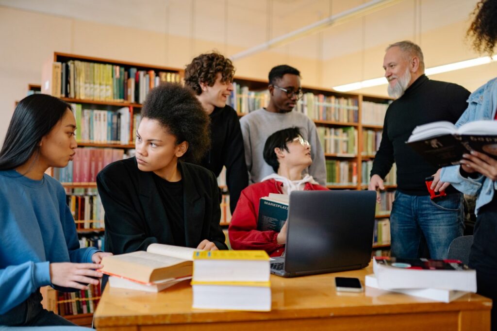 pexels photo 8199558 A diverse group of students studying together at a university library, engaged in discussion.